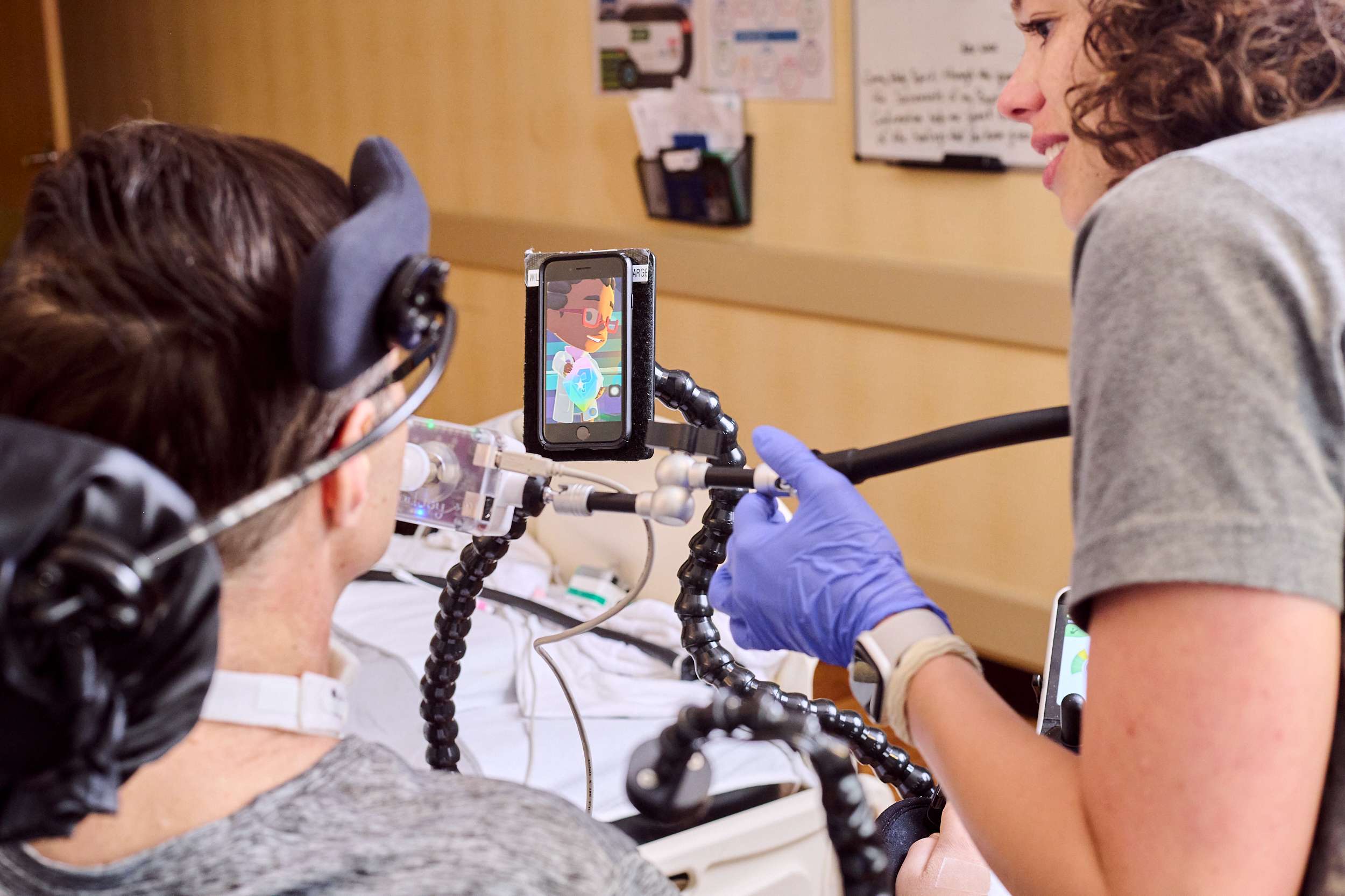 Patient learns how to use a mouth-controlled joystick to control his cell phone with the help of his assistive technology specialist.